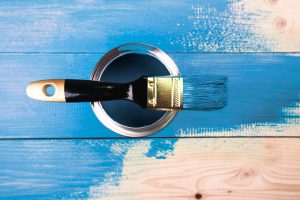 Painting in a blue color. Paint can with brush